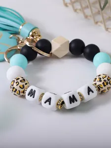 Detail van MAMA-kralen op een siliconen kralen sleutelhanger met een blauwe kwastje hanger