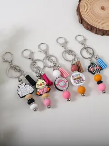 Diverse collection of silicone bead keychains with tassels and themed charms.