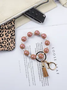 Close-up view of a beaded keychain bracelet with macaron silicone beads and small tassel