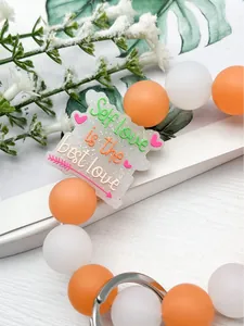 Detalle de llavero de cuentas de silicona con colgante Self love