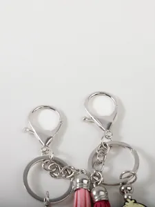 Close-up detail of silver lobster clasps and pink tassel on American-style silicone keychains