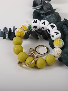 Gros plan sur porte-clés en perles de silicone avec motifs floraux et cubes MAMA
