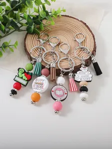Close-up of colorful silicone bead keychains with tassels and book charms for school.