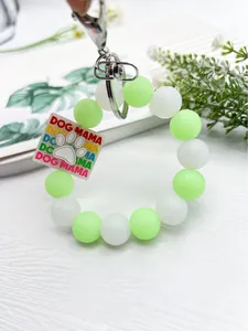 Detalle de un llavero de cuentas de silicona fluorescente con un amuleto de Dog Mama
