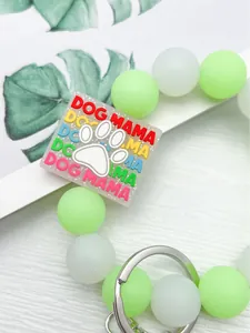 Detalle de pulsera de cuentas de silicona luminosa con dije colorido de DOG MAMA