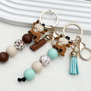 Llavero de cuentas de silicona vaca Highland con borla de ante sintético y dije para bolso.