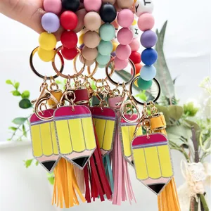 Llavero de cuentas de silicona de colores con dije de lápiz y borla decorativa