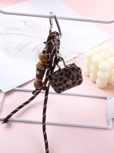 Detailed macro shot of a leopard print leather coin purse keychain with braided cord.