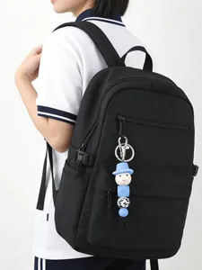 Close-up view of a cute blue cartoon bead charm accessory hanging on a black backpack