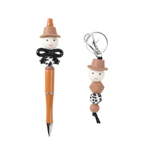 Cute cartoon cowboy beaded ballpoint pen and matching keychain set with cow print beads.
