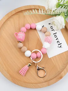 Macro view of beaded bracelet keychain with Nurse Life cup charm and pink tassel