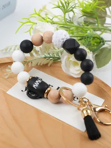 Close-up detail of silicone beaded keychain featuring MAMA mug charm and black tassel accessory