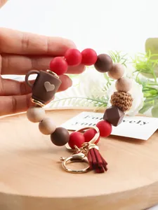 Detail view of a silicone and wood bead keychain wristlet with a coffee cup charm