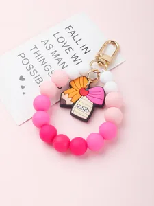 Macro detail of silicone beaded keychain bracelet with pink gradient and teacher charm