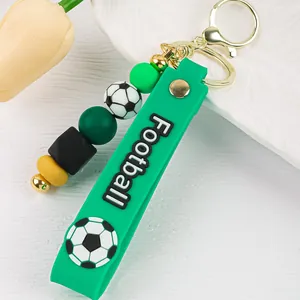 Primer plano de llavero de fútbol de silicona verde con cuentas y anillo dorado