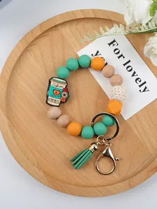Close-up detail of silicone and wood beaded keychain wristlet with coffee cup charm and tassel