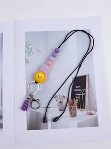 Detailed view of handmade silicone sun and rainbow bead keychain with purple tassel