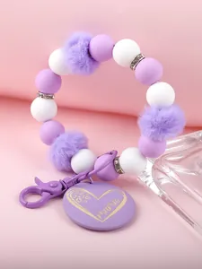 Detailansicht des lila-weißen Silikonperlen-Armbands mit Plüschbällen und Mama-Anhänger