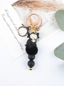 Detail of black highland cow keychain with silicone beads and soft fur pom pom
