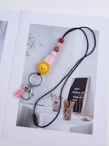 Detailed shot of a cartoon sun silicone bead lanyard with pink tassel and metallic clasp