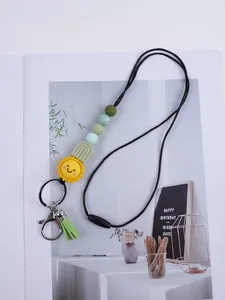 Handmade silicone beaded lanyard featuring a cartoon sun charm and vibrant green tassel detail