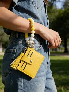 Close-up of yellow silicone bead wristlet keychain with PU leather tassel card holder