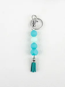 Detail of teal silicone bead keychain with octagonal bead and matching tassel charm
