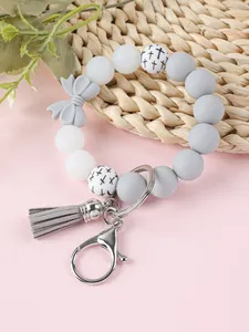 Gedetailleerde weergave van siliconen kralen armband sleutelhanger met strik en kwast