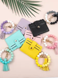 Collection of colorful PU leather card holders with silicone beaded wristlets and tassels.