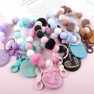 Bunte Silikonperlen-Armband-Schlüsselanhänger mit Pompons und Mama-Herz-Anhängern.