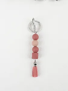 Close-up of DIY pink silicone bead keychain with octagonal bead and tassel pendant charm