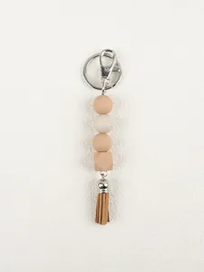 Detailed view of a silicone bead keychain with an octagonal bead and leather tassel.