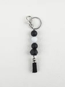 DIY silicone beaded keychain with octagonal bead and black tassel on white background