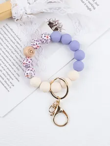 Detailed close-up of silicone beaded wristlet keychain with floral and wooden beads