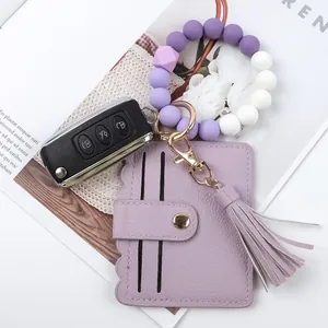 Silicone beaded keychain bracelet with purple PU leather card wallet and tassel detail.