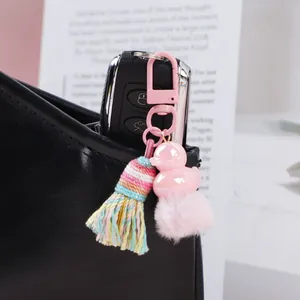 Handmade woven tassel keychain featuring a pink duck charm and soft pom-pom ornament