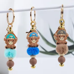 Cartoon highland cow keychain set with silicone beads and fluffy fur ball pom poms