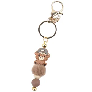 Cute highland cow keychain with silicone beads and brown faux fur pom pom bag charm.