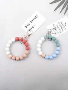 Detailed view of colorful silicone and natural wood beaded wristlet keychains with metal clasps