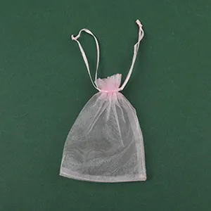 Détail d'un sac cadeau en organza rose avec cordon pour bijoux faits main et accessoires