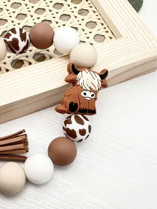 Detailed view of silicone bead keychain wristlet with cute brown highland cow charm
