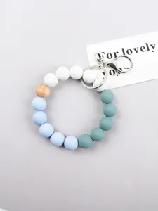 Close-up of pastel silicone and wood beads on a keychain with a silver clasp