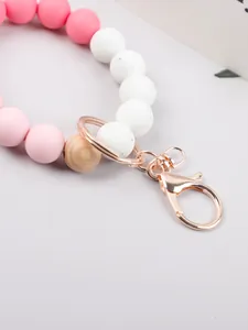 Detailed view of candy-colored silicone and wooden bead keychain with rose gold clasp
