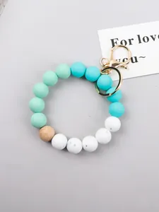 Close-up of mint green and blue silicone beaded keychain with wooden bead detail
