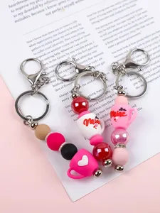 Gros plan sur les porte-clés en perles silicone avec tasses Be Mine pour Saint-Valentin