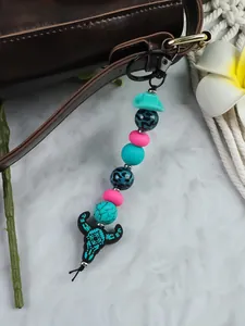 Detailed view of western cowboy bull head beaded keychain charm with turquoise hat