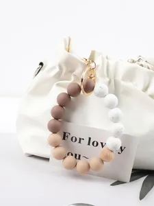 Detail shot of a stylish silicone and wood bead keychain charm in earthy gradient tones.