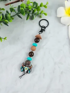 Detailed view of Western cowboy bull skull keychain with turquoise beads and hat charm