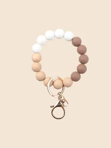 Detail view of a silicone beaded wristlet keychain featuring earth tones and wood bead