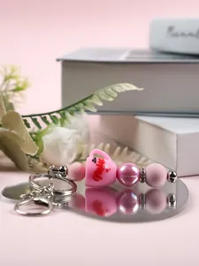 Gros plan détaillé d'un porte-clés en perles de silicone rose avec tasse Be Mine